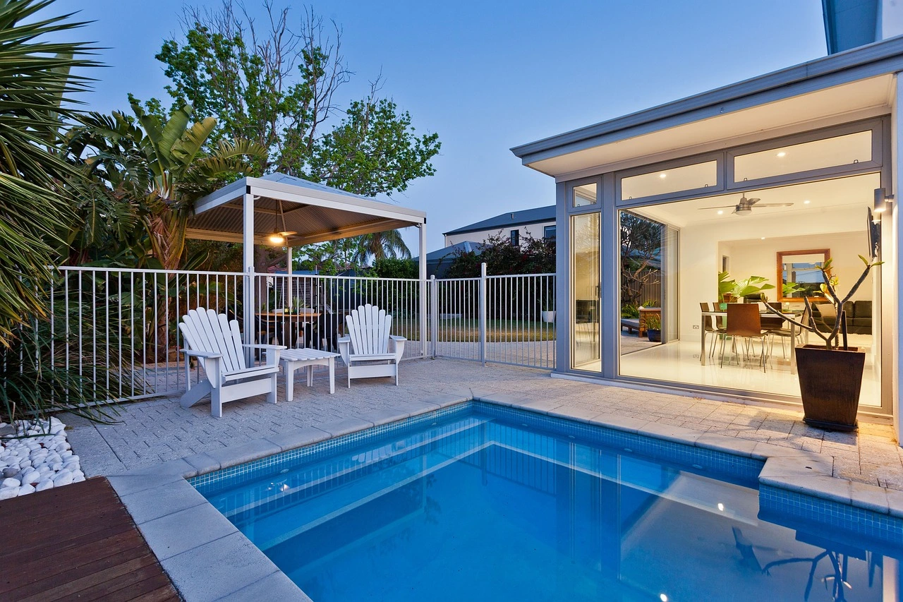 Two white lounge chairs overlooking a beautiful swimming pool with crystal-clear water