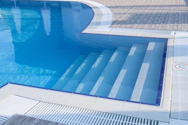 Pool technician repairing damaged pool steps, ensuring safety and stability.
